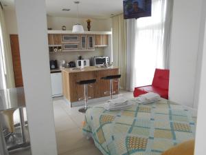 a room with a bed and a kitchen with a table at Depto Tipo Apart in Salta