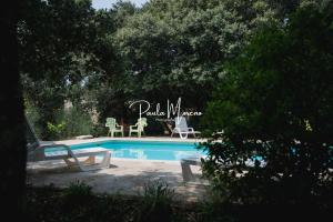a swimming pool with a table and chairs next to it at Gite Pellerin in Montbrison-sur-Lez
