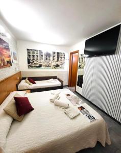 una camera da letto con due letti e una TV a parete di A&F Colosseo a Roma