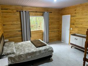 a bedroom with wooden walls and a bed and a window at IguassuEcoHostel - Eco Suítes - Hostel mais próximo das Cataratas in Foz do Iguaçu +113 photos