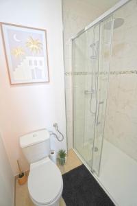 Un baño con inodoro y ducha de cristal. en Studio neuf parking gratuit 15 minutes de Lyon, en Francheville