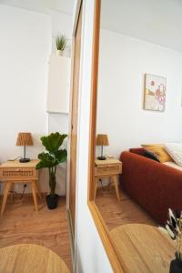 sala de estar con sofá rojo y 2 mesas en Studio neuf parking gratuit 15 minutes de Lyon, en Francheville