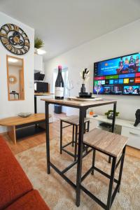 Sala de estar con mesa y botella de vino en Studio neuf parking gratuit 15 minutes de Lyon, en Francheville