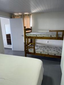 ピニェイラにあるResidencial Wrubleski SCの二段ベッド2台とテーブルのある寝室
