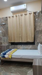 a bed in a room with a curtain at Marquis Luxe Guest House in Kolkata +17 photos
