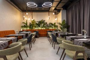 a dining room with tables and chairs and plants at Silver Apart in Truskavets
