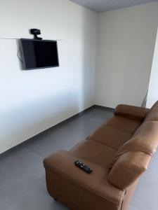 ピニェイラにあるResidencial Wrubleski SCのリビングルーム(ブラウンソファ、テレビ付)