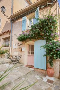 a building with a pink door and flowers at La Recampado in Bormes-les-Mimosas