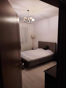 a bedroom with a bed and a chandelier at Appartment in the center of town Fushe Kosova in Kosovo in Kosovo Polje