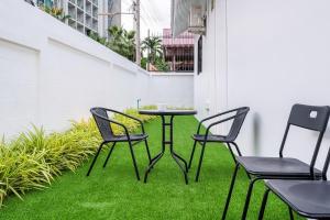 パタヤ・ノースにあるVilla 35 Wongamat 4BR, 300m from BEACHのパティオ(芝生付)のテーブルと椅子