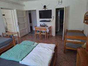a room with a bed and a table and a tv at Flamingo Apartman in Sopron