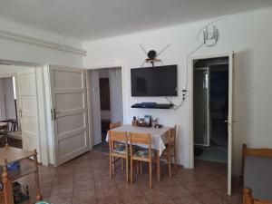 a dining room with a table and a tv on the wall at Flamingo Apartman in Sopron