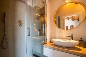 a bathroom with a sink and a shower with a mirror at Loft con terrazzo sulla Scala in Caltagirone