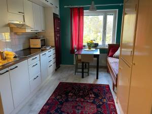 cocina con armarios blancos y cortina roja en Jokioinen-Forssa apartment 48m2, en Jokioinen