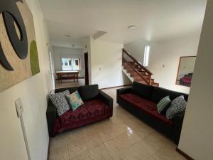 a living room with two couches and a staircase at Residencial Beira Mar in Florianópolis