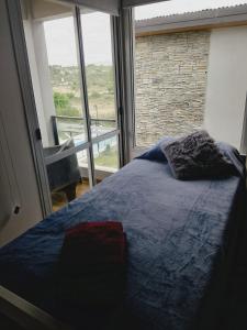 a bedroom with a bed and a large window at Encanto Serrano II in Villa Carlos Paz