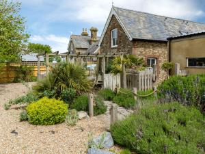 a stone house with a fence and a garden at Point Farm in Rye