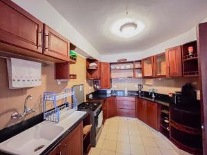 蒙巴萨Mwafrika Beachfront Apartments的配有木质橱柜、水槽和炉灶的厨房