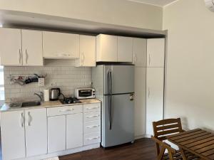 a kitchen with white cabinets and a refrigerator at Modern chic rooftop studio in Sheikh Zayed