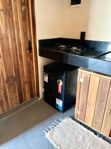 a black microwave sitting next to a door at Rancho do vagalume in Camocim