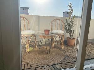 een paar stoelen en een tafel op een balkon bij Modern chic rooftop studio in Sheikh Zayed