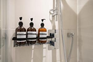 a rack with four bottles of alcohol on a shower door at Central Manchester Spacious Apartment with Free Parking in Manchester