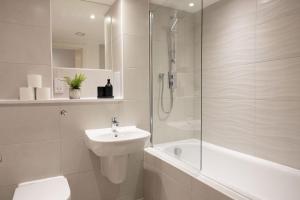 a bathroom with a shower and a sink and a toilet at Central Manchester Spacious Apartment with Free Parking in Manchester