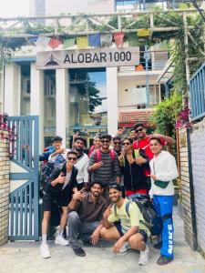 a group of people posing in front of a door at Alobar1000 Hostel in Kathmandu