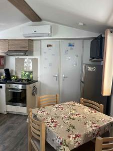 カネ・アン・ルシヨンにあるmobil home CANETのテーブル付きのキッチンと冷蔵庫付きのキッチン