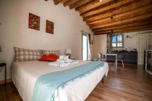 a bedroom with a large bed and a kitchen at Loft con terrazzo sulla Scala in Caltagirone