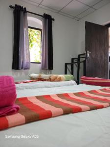 two beds sitting next to each other in a room at Ella Cool Air Cabana in Ella