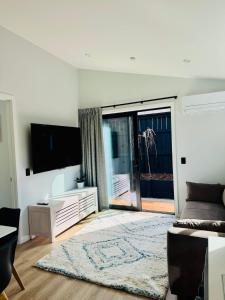 a living room with a couch and a tv at Hiking Golf Skiing Lake Remarkables 7 Min Airport in Queenstown