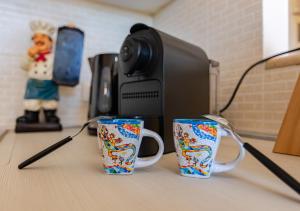 three coffee mugs sitting on top of a desk at Hostly-La Casa di Giada-Near Pisa, Lucca, Seaside in Navacchio