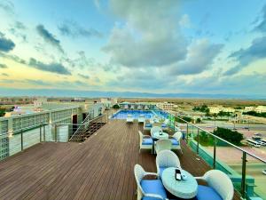 a deck with chairs and tables on a cruise ship at Salalah International Hotel in Salalah