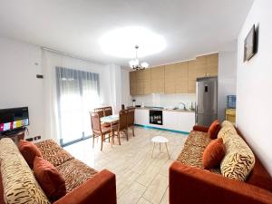 a living room with two couches and a kitchen at Durres Escape by sea in Golem