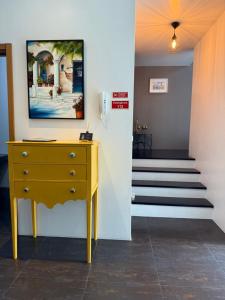 a yellow dresser in a hallway with a staircase at CASA Raiz in Ponta Delgada