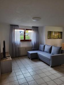a living room with a blue couch and a window at Apartment HESS in Rust