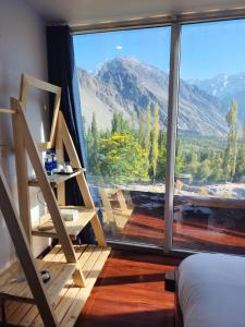 a room with a large window with a mountain view at Belle Epoque Mountain Resort, Hunza, Gilgit Baltistan in Hunza