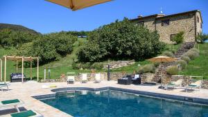 a pool with chairs and umbrellas and a building at Ca Quattrocchi 10&3 by Marche Holiday Villas in Apecchio
