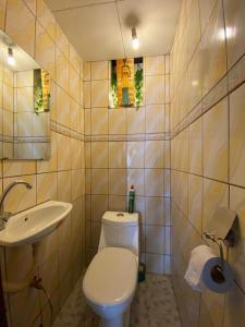 a bathroom with a white toilet and a sink at Appartement haut standing Mimboman in Yaoundé +10 photos