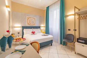 een hotelkamer met een bed en tafels en stoelen bij Hotel Suite Caesar in Rome