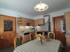 a kitchen with a table with a vase of flowers on it at Ferienhaus Schlössl Wildschönau WILD446 in Dorf +22 photos