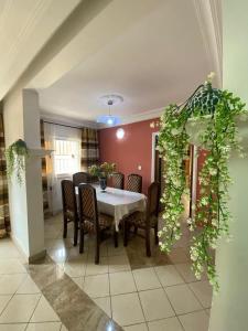 a dining room with a white table and chairs at Appartement haut standing Mimboman in Yaoundé