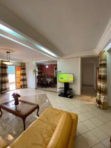 a living room with a couch and a tv at Appartement haut standing Mimboman in Yaoundé