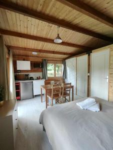a bedroom with a bed and a table and a kitchen at Botanique in Prunay-Cassereau