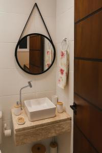 a bathroom with a sink and a mirror at Studio Super Luxo - Novo & Confortável in Uruguaiana