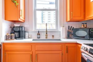 a kitchen with orange cabinets and a sink and a window at Prime Location Top Rated Clean Parking Free! in Columbus