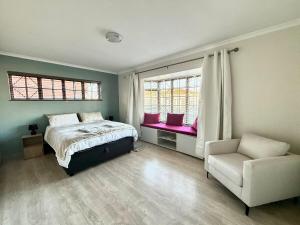Un dormitorio con una cama y una silla y ventanas. en Spacious 3 Bedroom 2 Bathroom, en Southfield