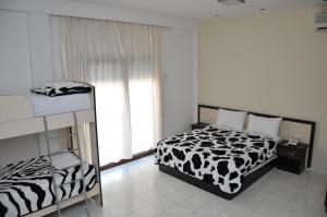 a bedroom with a black and white bed and a window at Sunrise Hotel Cameria in Durrës