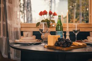 ein Tisch mit einer Flasche Wein und Weingläsern in der Unterkunft Piilotupa in Inari